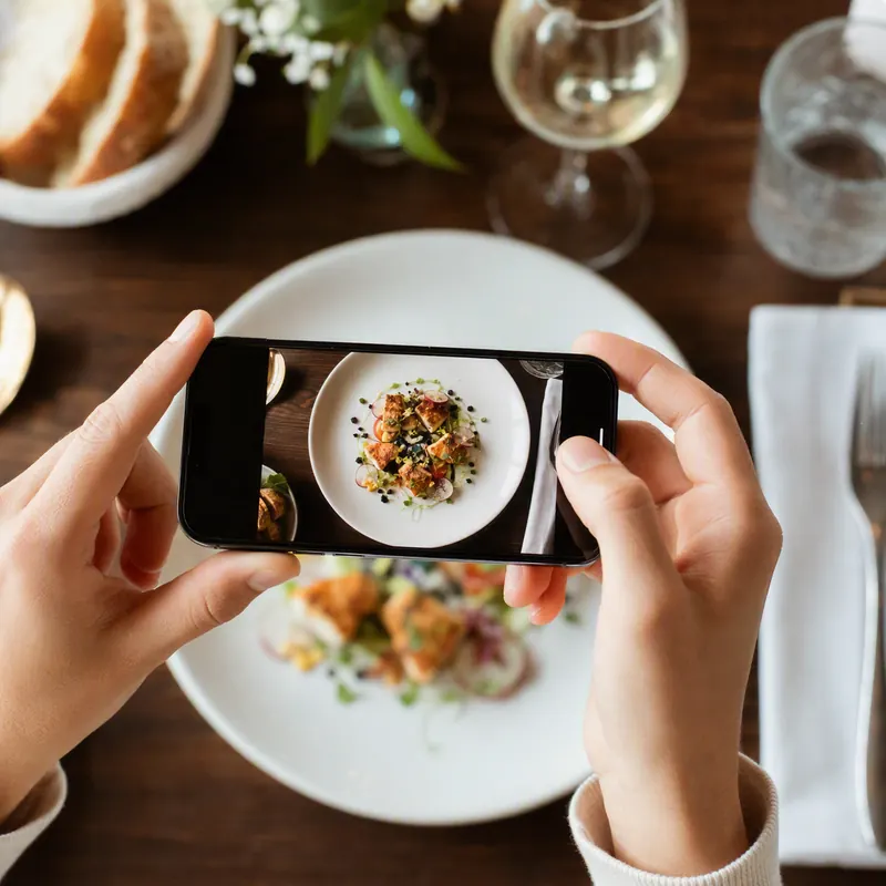 Pessoa fotografando prato de comida com o celular para montar cardápio digital